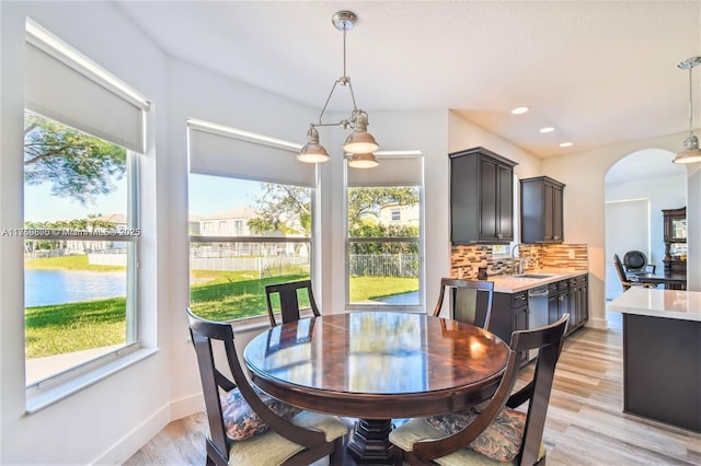 dining room with baseboards, light wood-style floors, recessed lighting, and a healthy amount of sunlight