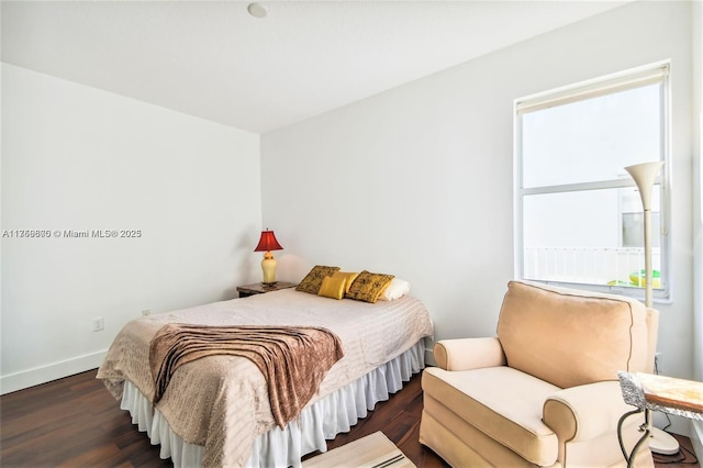 bedroom with dark wood-style floors and baseboards