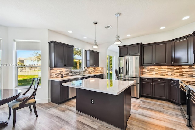 4951 SW 158th Ave, Miramar, FL 33027 - kitchen with appliances with stainless steel finishes, arched walkways, light countertops, tasteful backsplash, and a kitchen island