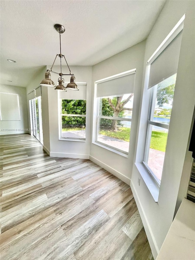 4951 SW 158th Ave, Miramar, FL 33027 - unfurnished dining area featuring a chandelier, healthy amount of natural light, wood finished floors, and a textured ceiling