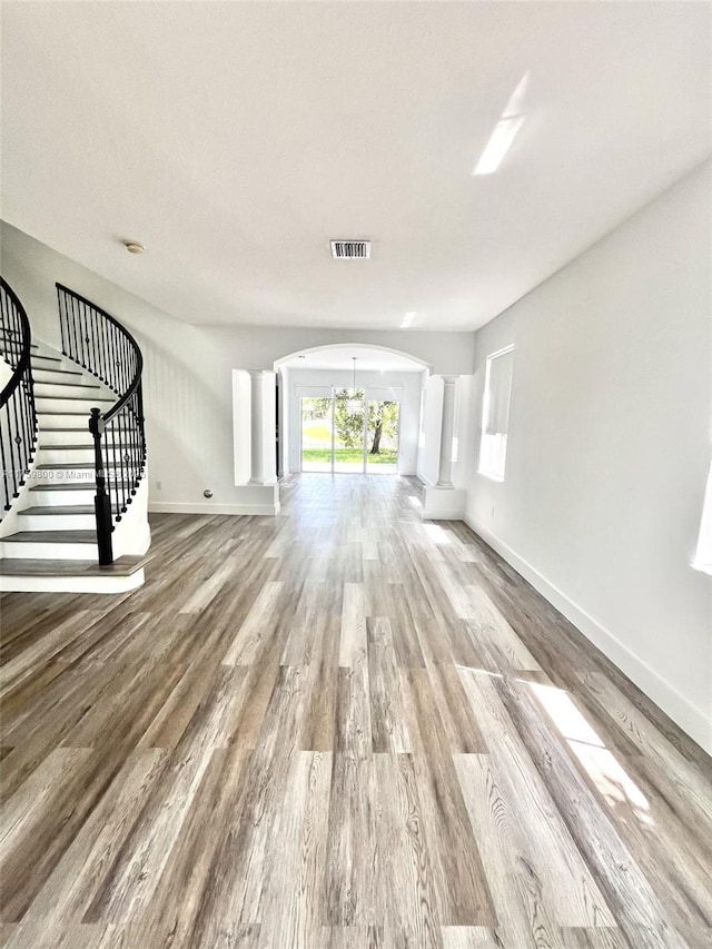 4951 SW 158th Ave, Miramar, FL 33027 - unfurnished living room featuring arched walkways, decorative columns, stairs, and wood finished floors