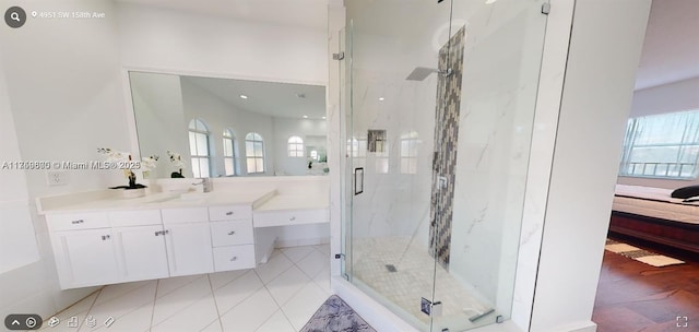 full bathroom featuring tile patterned floors, vanity, a marble finish shower, and ensuite bathroom