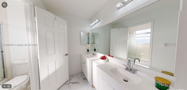 full bath featuring toilet, marble finish floor, two vanities, and a sink