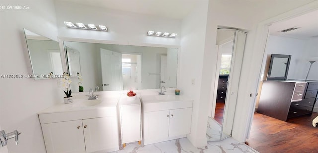 bathroom with marble finish floor, visible vents, two vanities, and a sink