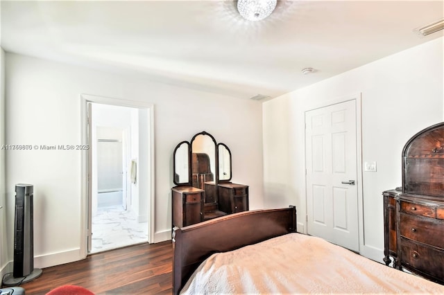 bedroom with visible vents, dark wood finished floors, ensuite bath, and baseboards