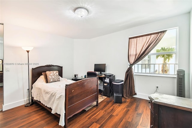 bedroom with wood finished floors and baseboards