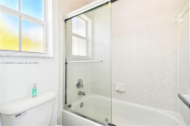 full bathroom with toilet and bath / shower combo with glass door