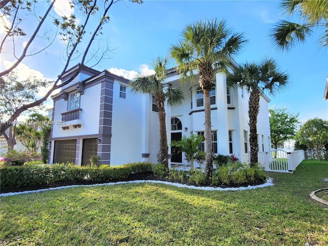 view of front of home with an attached garage, fence, a gate, stucco siding, and a front yard