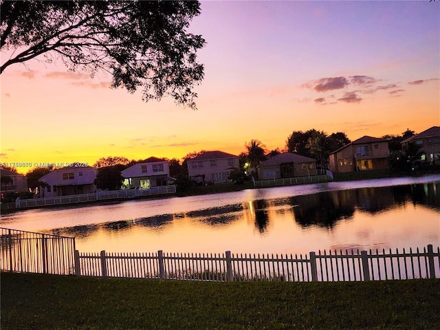 view of water feature with a residential view and fence