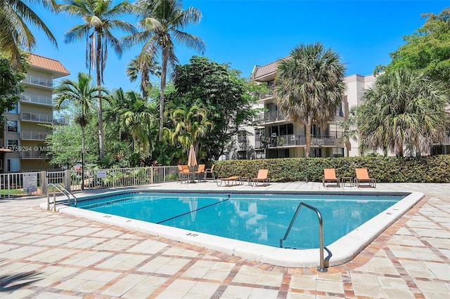 pool with a patio area and fence