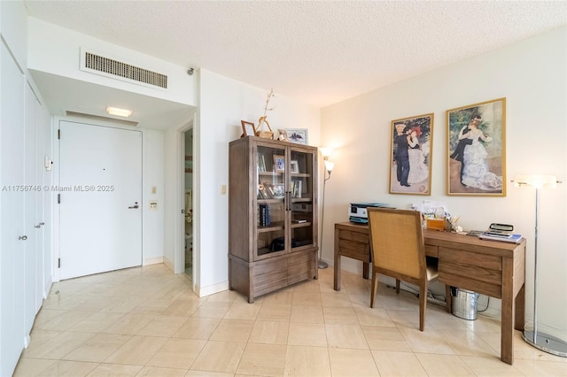 home office with baseboards, visible vents, and a textured ceiling