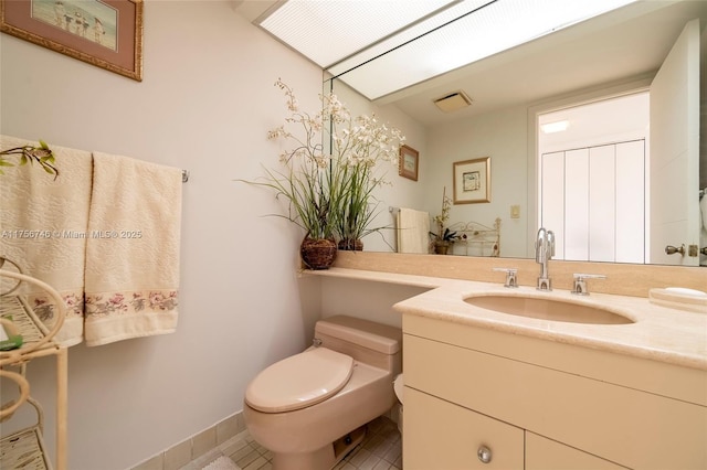 bathroom with toilet, tile patterned flooring, and vanity