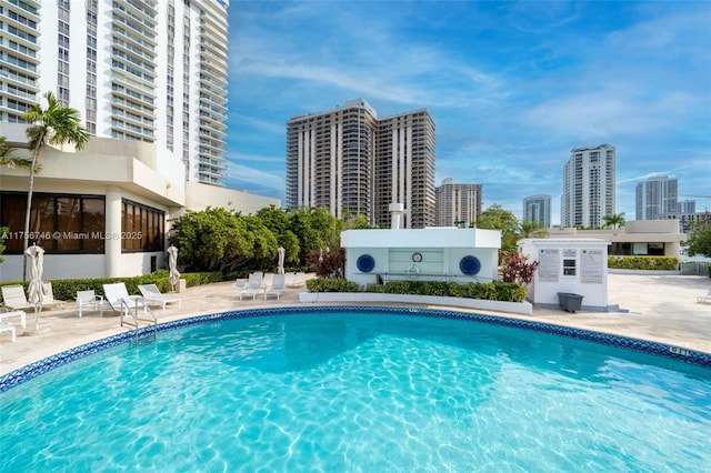 community pool featuring a view of city and a patio