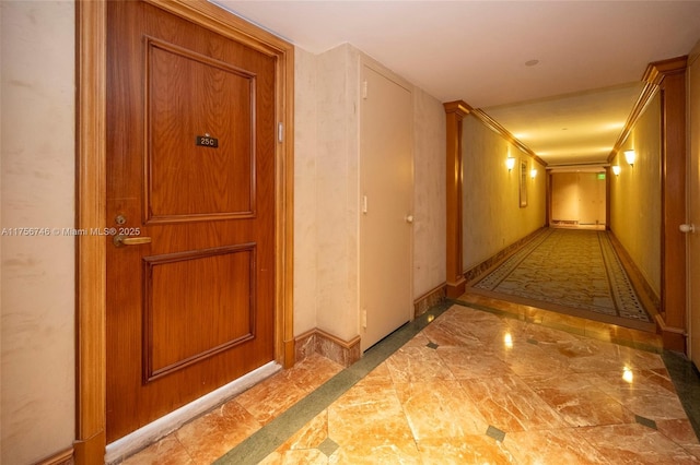 hallway with marble finish floor and baseboards