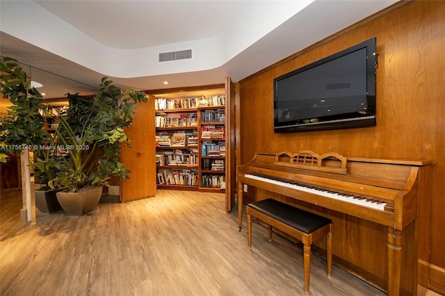 living area featuring visible vents and wood finished floors