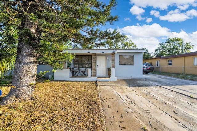 view of front of property featuring driveway and fence