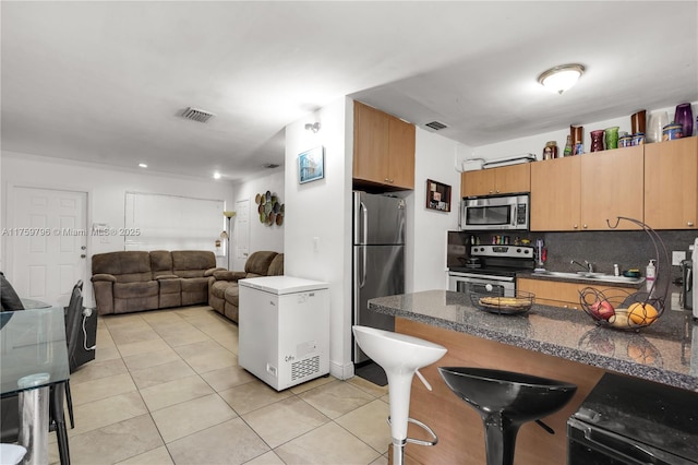 kitchen featuring tasteful backsplash, visible vents, appliances with stainless steel finishes, and light tile patterned floors