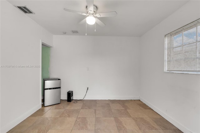 unfurnished room with visible vents, baseboards, and ceiling fan