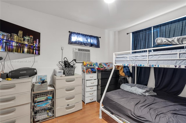 bedroom featuring a wall mounted AC and light wood-style floors