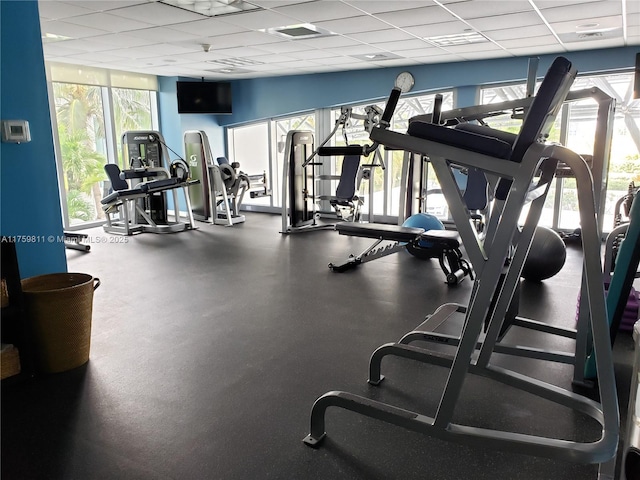 exercise room with a paneled ceiling and visible vents