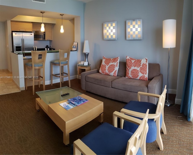 carpeted living area featuring baseboards and visible vents