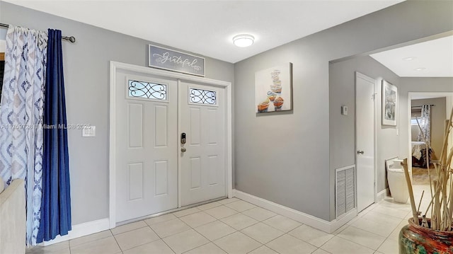 entryway featuring light tile patterned floors, visible vents, and baseboards