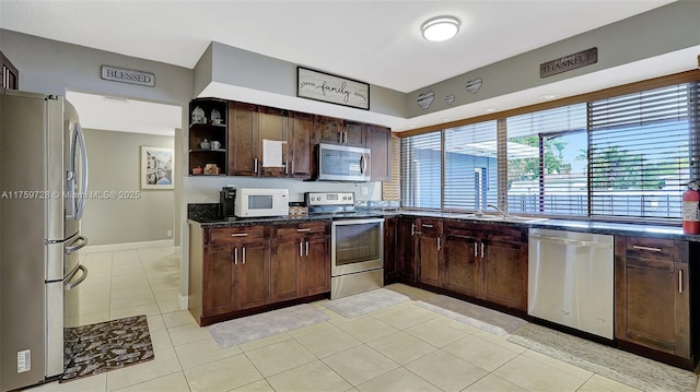 kitchen with open shelves, dark brown cabinets, and stainless steel appliances