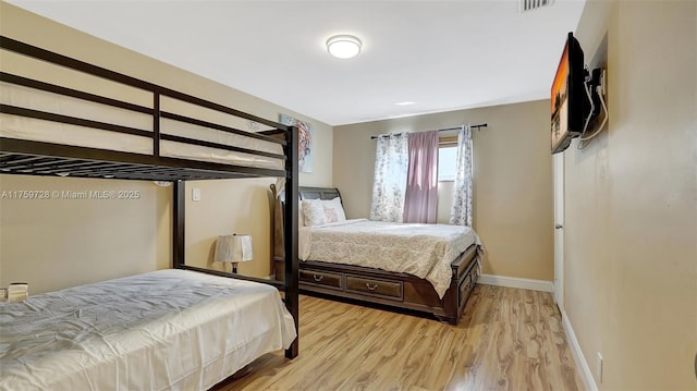 bedroom featuring light wood-type flooring, baseboards, and visible vents