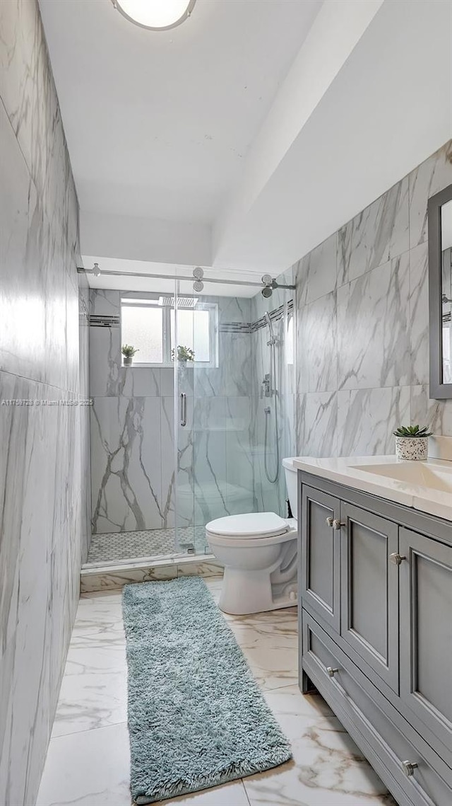 bathroom with a marble finish shower, marble finish floor, tile walls, and toilet