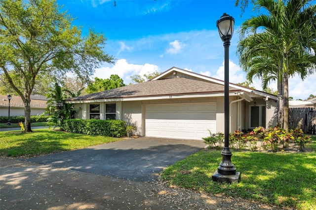 single story home with stucco siding, driveway, a front lawn, and a garage