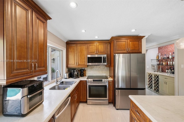 17 Boxwood Rd, Hollywood, FL 33021 - kitchen featuring a sink, light countertops, brown cabinetry, and stainless steel appliances