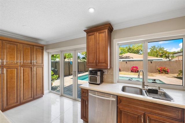 17 Boxwood Rd, Hollywood, FL 33021 - kitchen with light countertops, a wealth of natural light, stainless steel dishwasher, brown cabinetry, and a sink