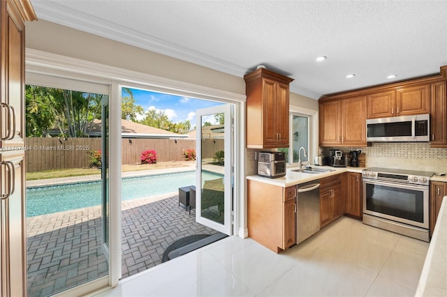 17 Boxwood Rd, Hollywood, FL 33021 - kitchen with a sink, decorative backsplash, light countertops, stainless steel appliances, and brown cabinets