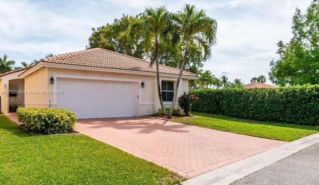 view of front of house with a garage, decorative driveway, a front yard, and stucco siding