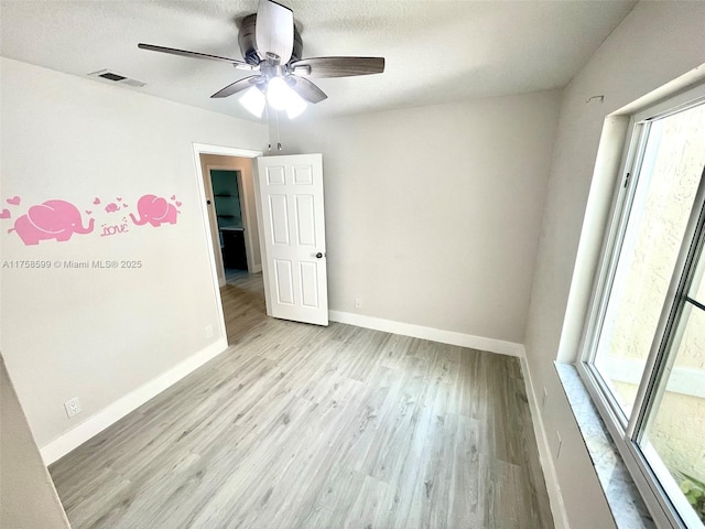 unfurnished room with baseboards, visible vents, ceiling fan, a textured ceiling, and light wood-type flooring