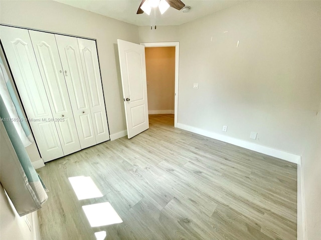 unfurnished bedroom featuring a closet, wood finished floors, a ceiling fan, and baseboards