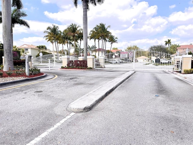 view of road with a gate, curbs, and a gated entry