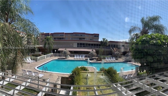 pool with a patio area and fence