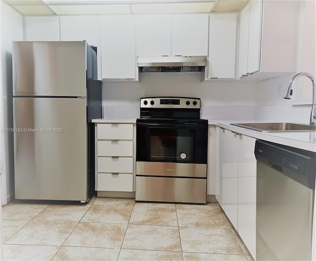 kitchen with light countertops, appliances with stainless steel finishes, white cabinetry, a sink, and under cabinet range hood