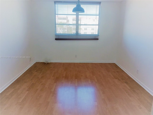 unfurnished room featuring light wood finished floors and baseboards