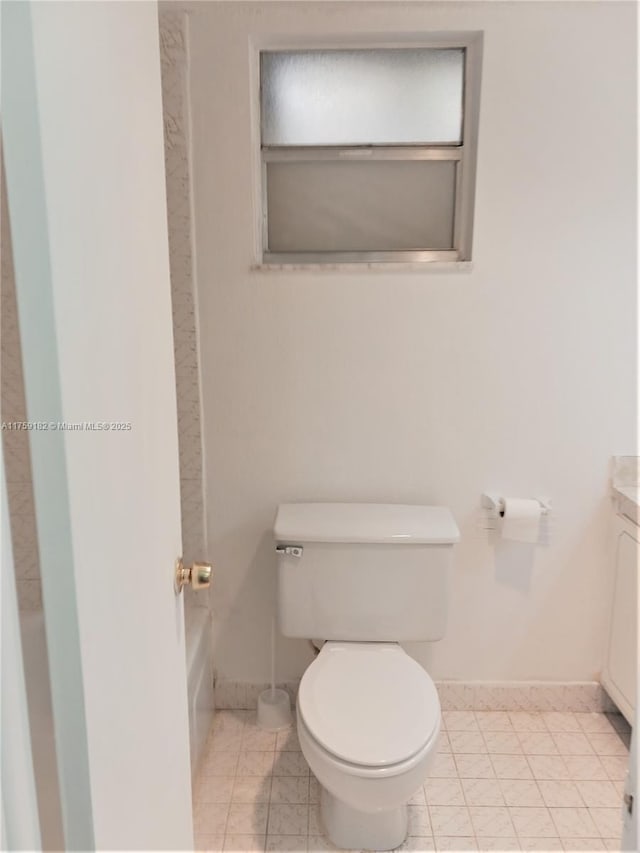 full bathroom with tile patterned flooring, baseboards, vanity, and toilet