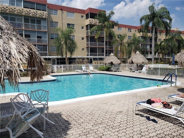 community pool with fence and a patio