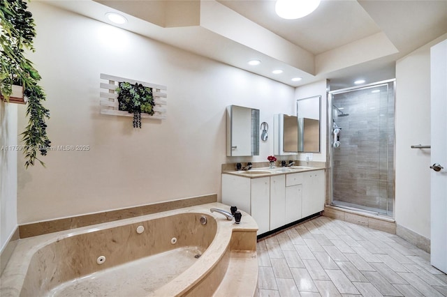 full bathroom featuring wood tiled floor, double vanity, a sink, a shower stall, and a jetted tub