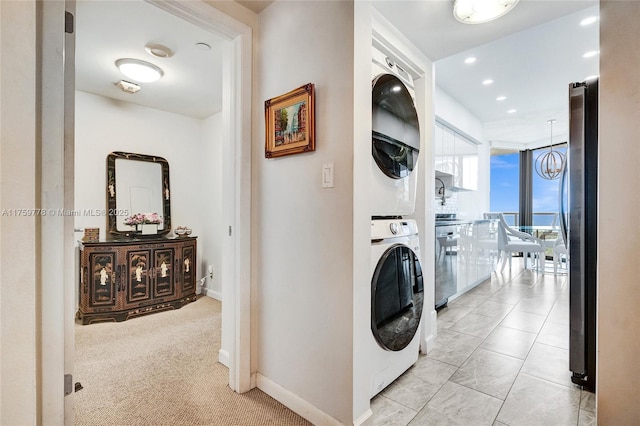 washroom featuring baseboards, an inviting chandelier, laundry area, recessed lighting, and stacked washer / drying machine