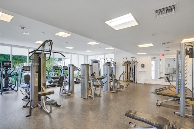 gym with floor to ceiling windows, baseboards, and visible vents