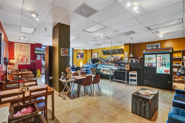 dining area featuring track lighting and a paneled ceiling