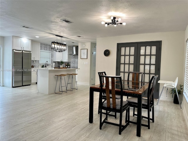 5127 Glasgow Ave, Orlando, FL 32819 - dining room featuring visible vents, a textured ceiling, and a notable chandelier
