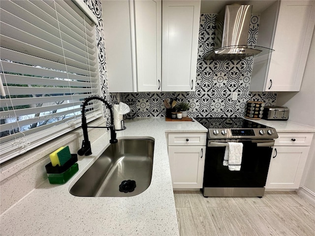 5127 Glasgow Ave, Orlando, FL 32819 - kitchen with wall chimney range hood, stainless steel range with electric cooktop, a sink, and white cabinets