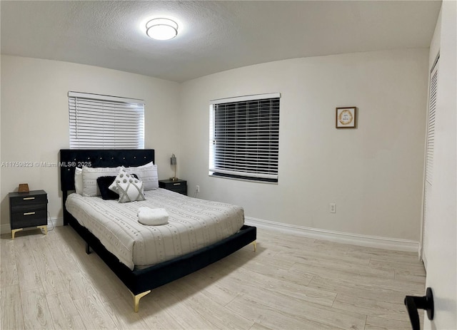 5127 Glasgow Ave, Orlando, FL 32819 - bedroom with light wood-style flooring, baseboards, and a textured ceiling