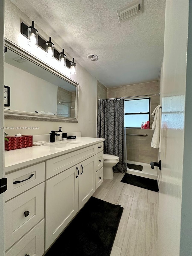 5127 Glasgow Ave, Orlando, FL 32819 - full bathroom with a textured ceiling, vanity, curtained shower, toilet, and visible vents